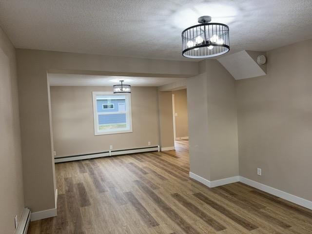 402 N Elba Ave, Eveleth, MN 55734 - unfurnished dining area with a chandelier, a baseboard radiator, wood finished floors, and a textured ceiling