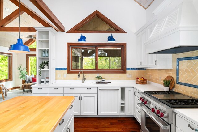596 W Wabasha St, Duluth, MN 55803 - kitchen featuring high end stove, premium range hood, white cabinets, and hanging light fixtures