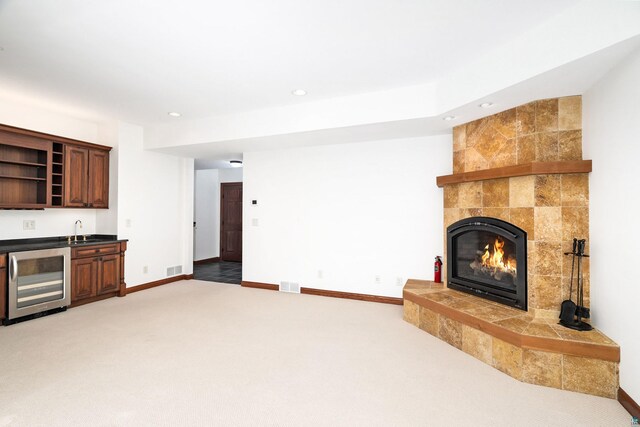 596 W Wabasha St, Duluth, MN 55803 - unfurnished living room with wine cooler, bar with sink, light carpet, recessed lighting, and a fireplace