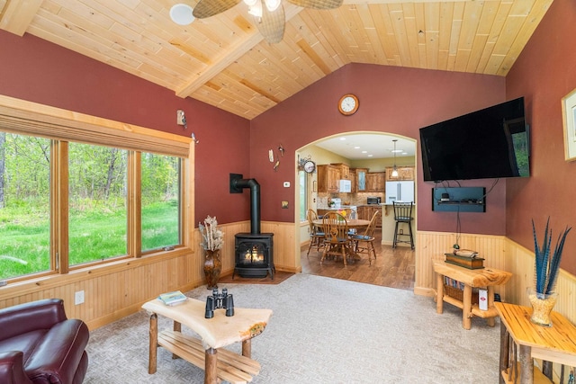 5036 Silver Leaf St, Hermantown, MN 55811 - living room featuring lofted ceiling, a wood stove, arched walkways, wainscoting, and ceiling fan
