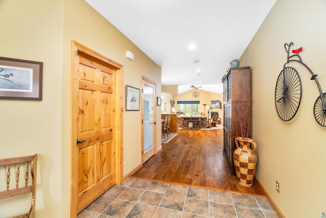 5036 Silver Leaf St, Hermantown, MN 55811 - corridor featuring lofted ceiling, baseboards, and dark stone finish floors