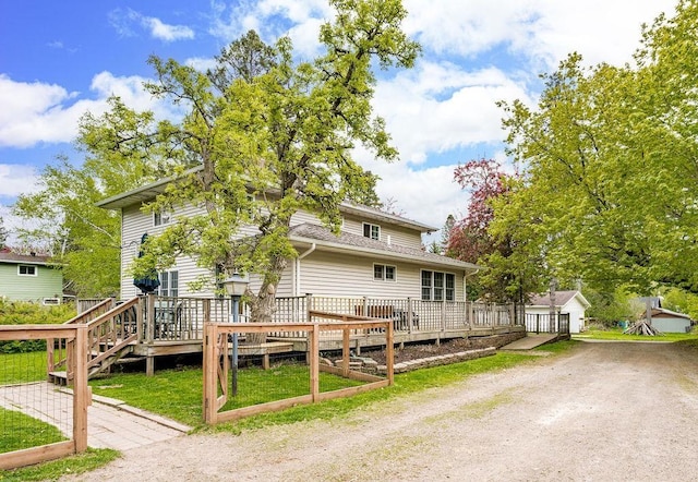 13107 W 9th St, Duluth, MN 55808 - rear view of house with a wooden deck, a lawn, driveway, and roof with shingles