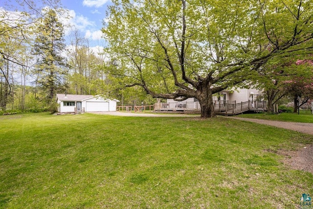 13107 W 9th St, Duluth, MN 55808 - view of green lawn featuring driveway, a wooden deck, a garage, and an outbuilding