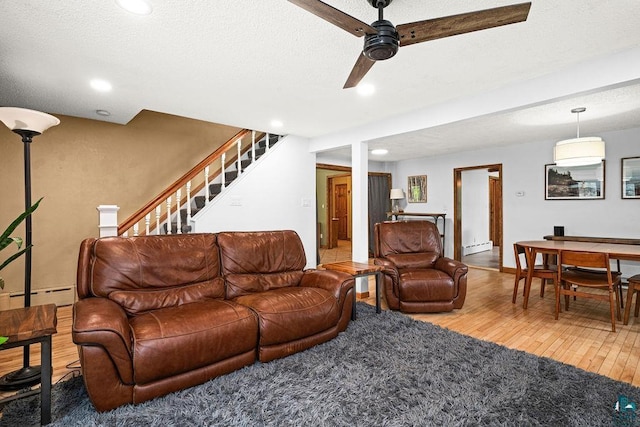 13107 W 9th St, Duluth, MN 55808 - living area with a baseboard heating unit, wood finished floors, stairway, ceiling fan, and recessed lighting