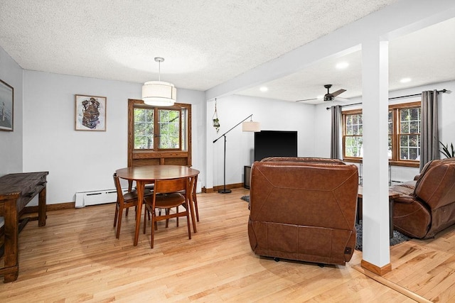 13107 W 9th St, Duluth, MN 55808 - dining room featuring light wood finished floors, a textured ceiling, ceiling fan, baseboards, and baseboard heating