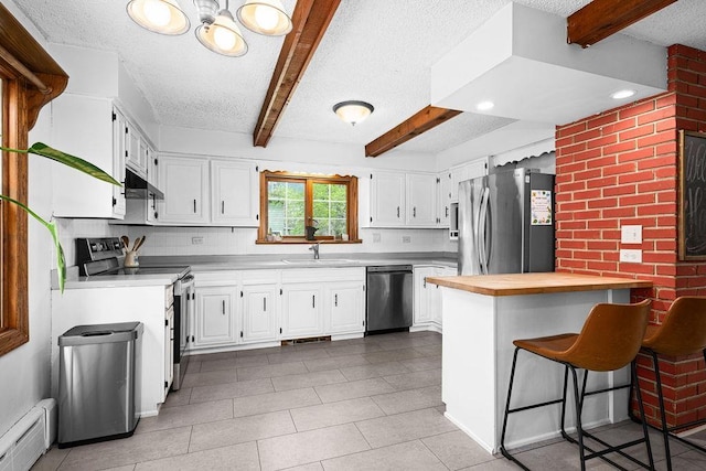 13107 W 9th St, Duluth, MN 55808 - kitchen with stainless steel appliances, baseboard heating, wooden counters, beamed ceiling, and a sink