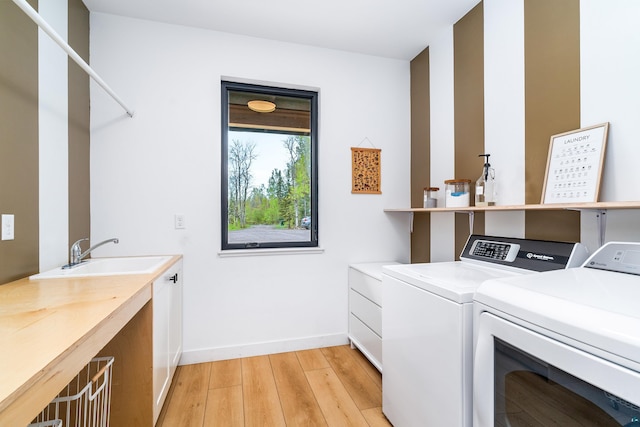 2413 Lismore Rd, Duluth, MN 55804 - washroom with separate washer and dryer, cabinet space, light wood-style flooring, and baseboards