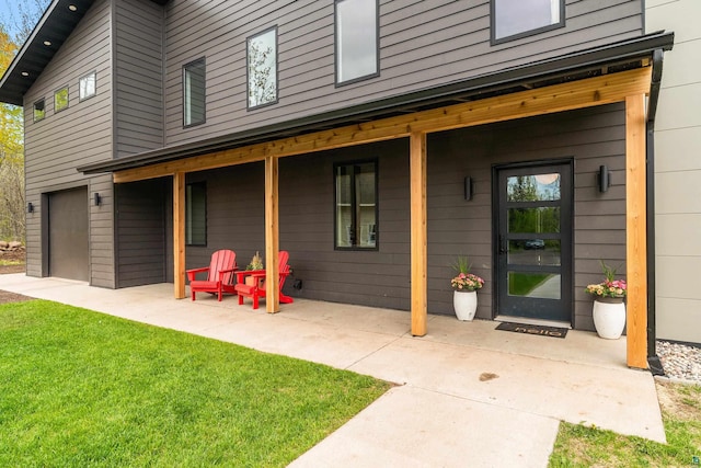 2413 Lismore Rd, Duluth, MN 55804 - view of exterior entry with a yard, an attached garage, and a patio