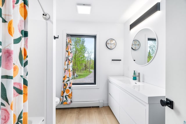2413 Lismore Rd, Duluth, MN 55804 - bathroom with vanity, baseboard heating, toilet, baseboards, and wood finished floors