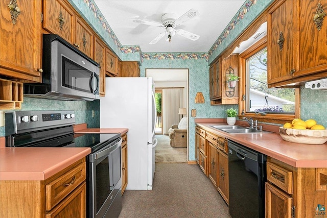 2715 Triggs Ave, Duluth, MN 55811 - kitchen with stainless steel appliances, wallpapered walls, carpet, a sink, and brown cabinetry