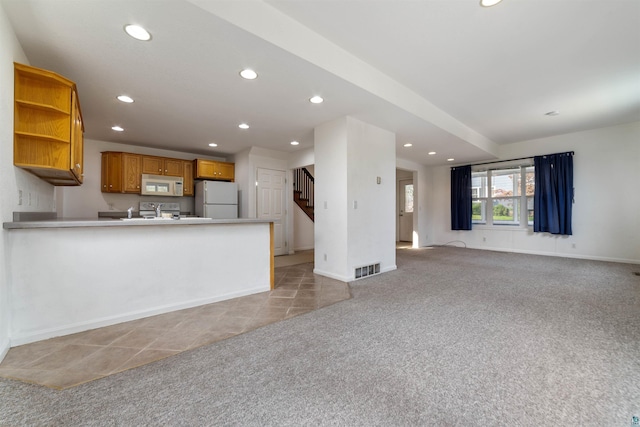 601 N 22nd Ave W, Duluth, MN 55806 - kitchen with white appliances, light colored carpet, recessed lighting, open floor plan, and a peninsula