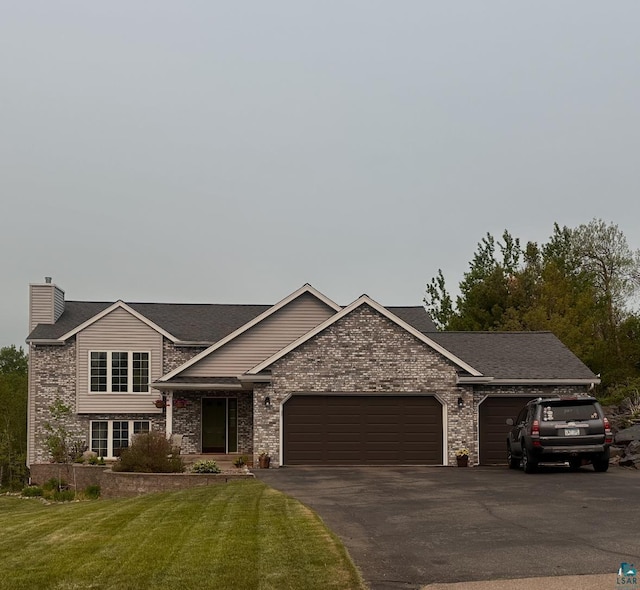 1505 Coachlight Crk, Proctor, MN 55810 - view of front of home featuring a garage, driveway, a front yard, a chimney, and brick siding