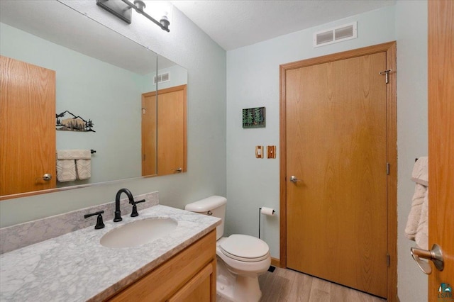 1505 Coachlight Crk, Proctor, MN 55810 - bathroom featuring vanity, wood finished floors, and toilet