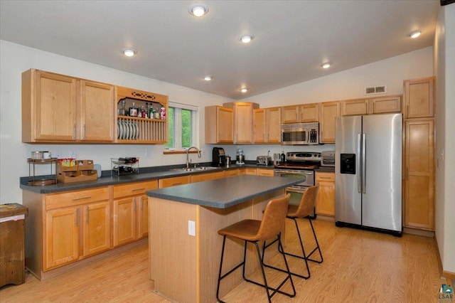 1505 Coachlight Crk, Proctor, MN 55810 - kitchen with appliances with stainless steel finishes, a sink, a breakfast bar, light wood-style floors, and lofted ceiling