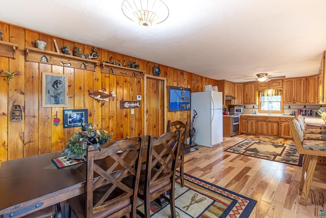 3984 Stocking Point Dr, Ely, MN 55731 - dining area with wooden walls, light wood finished floors, and a ceiling fan