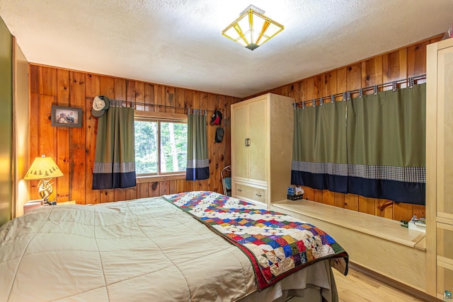 3984 Stocking Point Dr, Ely, MN 55731 - bedroom featuring wooden walls, a textured ceiling, and wood finished floors