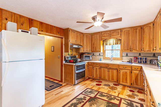 3984 Stocking Point Dr, Ely, MN 55731 - kitchen with freestanding refrigerator, double oven range, light countertops, light wood-style flooring, and under cabinet range hood