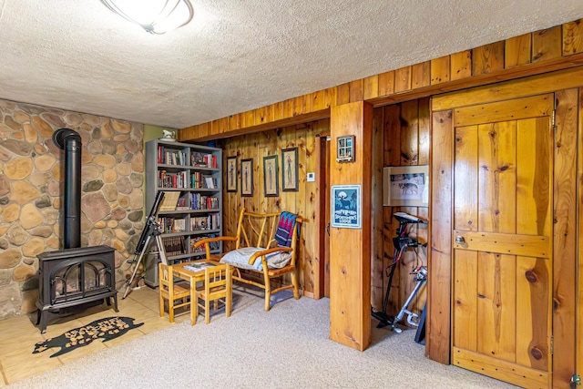 3984 Stocking Point Dr, Ely, MN 55731 - living area featuring a wood stove, a textured ceiling, wood walls, and carpet