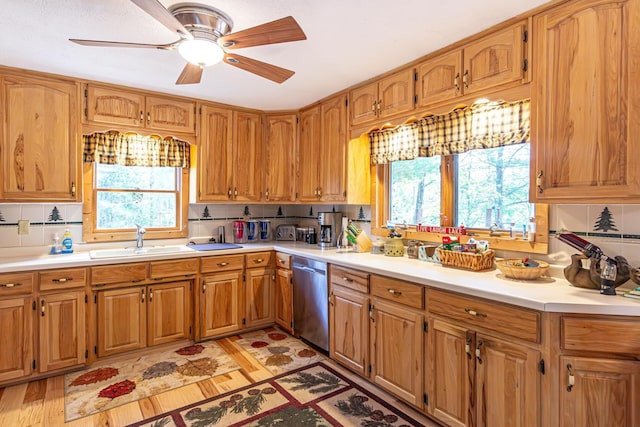 3984 Stocking Point Dr, Ely, MN 55731 - kitchen with stainless steel dishwasher, a sink, light countertops, and brown cabinetry