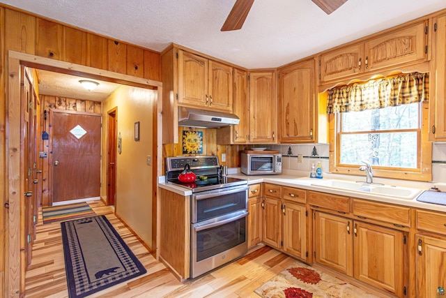 3984 Stocking Point Dr, Ely, MN 55731 - kitchen featuring stainless steel appliances, under cabinet range hood, a sink, light wood finished floors, and light countertops