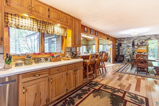 3984 Stocking Point Dr, Ely, MN 55731 - kitchen featuring stainless steel dishwasher, light wood-style flooring, a wood stove, and light countertops