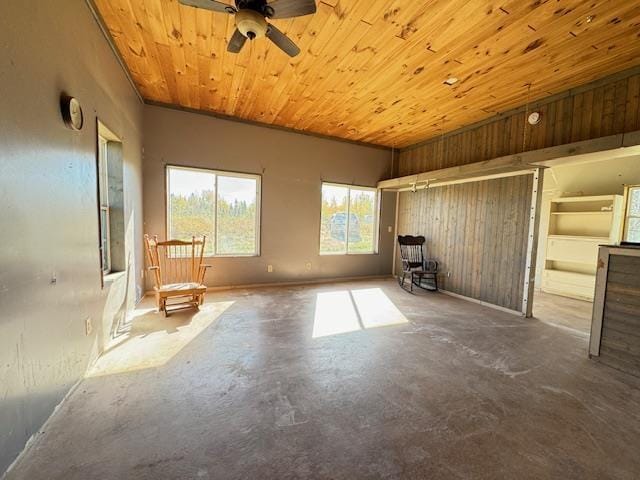 3217 Vermilion Trl, Makinen, MN 55763 - unfurnished living room featuring unfinished concrete floors, ceiling fan, wooden ceiling, and wood walls