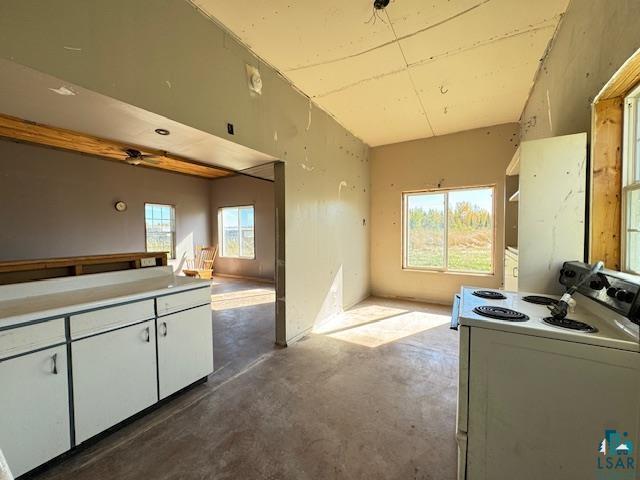 3217 Vermilion Trl, Makinen, MN 55763 - kitchen with white range with electric cooktop, concrete flooring, open floor plan, and white cabinets