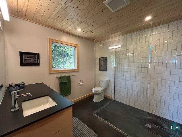 328 Gunflint Trl, Grand Marais, MN 55604 - bathroom featuring wooden ceiling, toilet, vanity, tiled shower, and recessed lighting