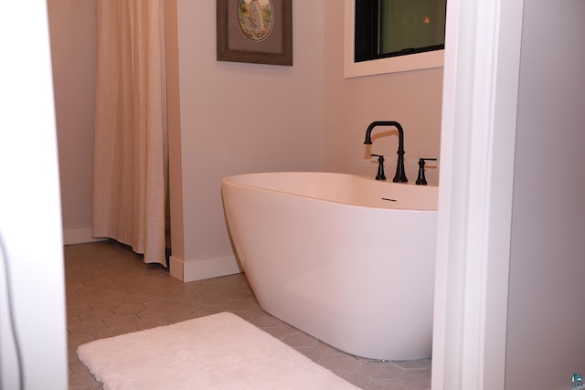 5004 W Rd, Moose Lake, MN 55767 - bathroom featuring a freestanding tub, tile patterned floors, and baseboards