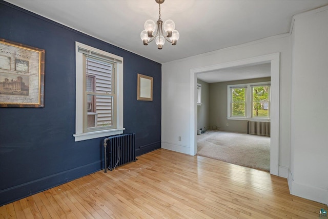 620 Hayes St, Eveleth, MN 55734 - spare room with radiator heating unit, a chandelier, hardwood / wood-style flooring, baseboards, and ornamental molding