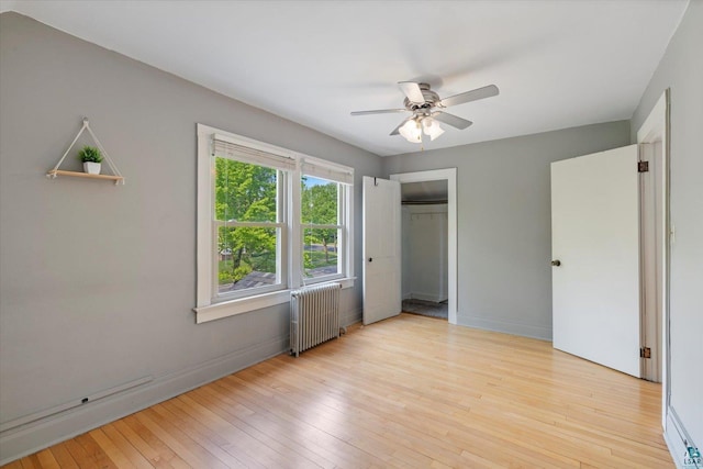 620 Hayes St, Eveleth, MN 55734 - unfurnished bedroom with radiator heating unit, baseboards, hardwood / wood-style floors, and a closet
