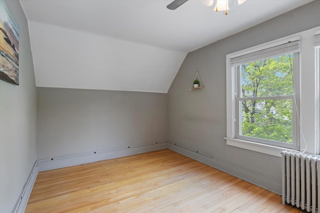 620 Hayes St, Eveleth, MN 55734 - additional living space featuring radiator heating unit, wood-type flooring, vaulted ceiling, healthy amount of natural light, and a ceiling fan