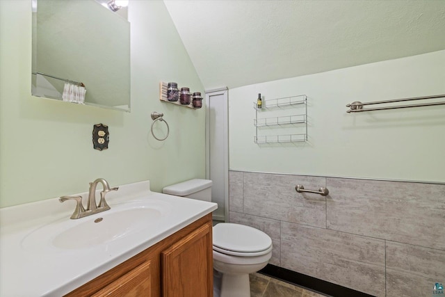 620 Hayes St, Eveleth, MN 55734 - full bathroom featuring toilet, vanity, lofted ceiling, wainscoting, and tile patterned floors