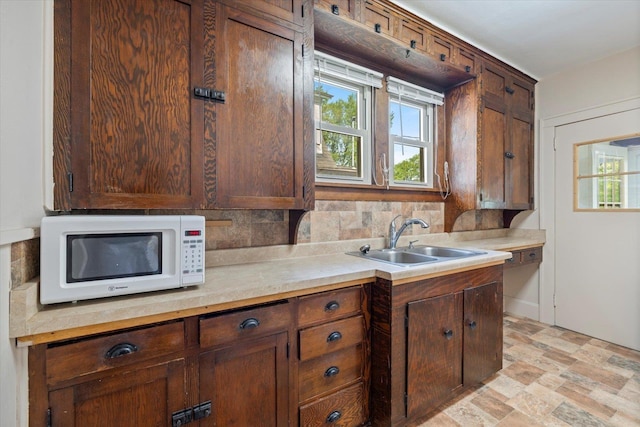 620 Hayes St, Eveleth, MN 55734 - kitchen with white microwave, a sink, tasteful backsplash, and light countertops
