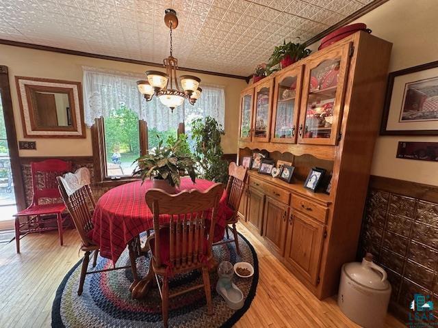 1601 W 4th Ave, International Falls, MN 56649 - dining room featuring ornamental molding, a chandelier, light wood-style floors, and an ornate ceiling