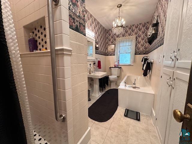 1601 W 4th Ave, International Falls, MN 56649 - full bathroom with wallpapered walls, toilet, a chandelier, tile patterned flooring, and a shower with shower curtain