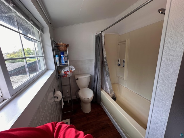 1601 W 4th Ave, International Falls, MN 56649 - full bath featuring tile walls, toilet, wood finished floors, shower / bathtub combination with curtain, and a wainscoted wall