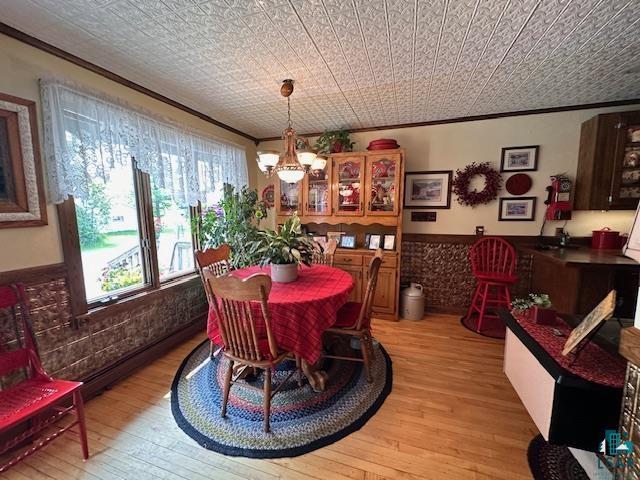 1601 W 4th Ave, International Falls, MN 56649 - dining space featuring light wood-style floors, crown molding, and a chandelier