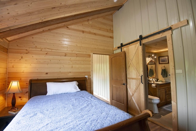 72 Sled Dog Trl, Hovland, MN 55604 - bedroom featuring a barn door, wooden walls, beam ceiling, a sink, and ensuite bathroom
