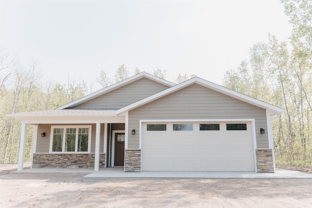 5036 W Arrowhead Rd, Hermantown, MN 55811 - craftsman house featuring stone siding, a garage, dirt driveway, and covered porch