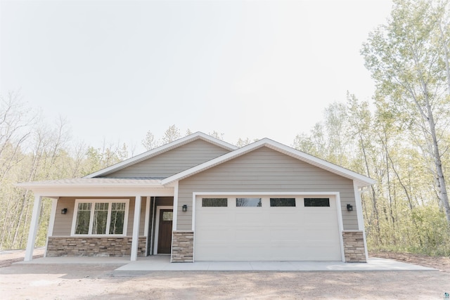 5036 W Arrowhead Rd, Hermantown, MN 55811 - view of front facade featuring stone siding, an attached garage, driveway, and a porch