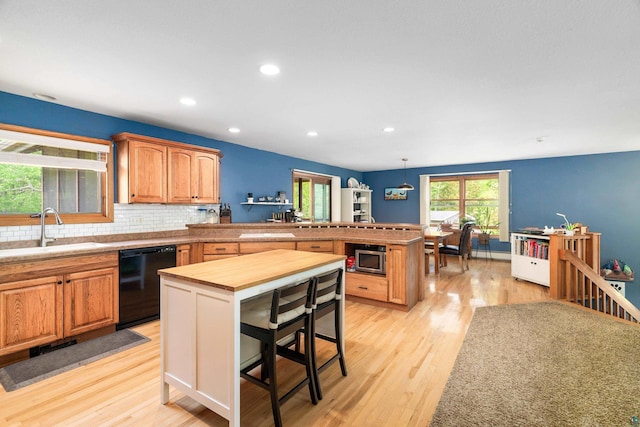 4409 Cedarway Rd, Duluth, MN 55810 - kitchen with black dishwasher, a sink, a peninsula, light wood-style floors, and stainless steel microwave