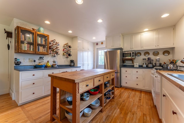 1 W Railroad St, Ely, MN 55731 - kitchen with appliances with stainless steel finishes, butcher block counters, white cabinetry, light wood-style flooring, and recessed lighting