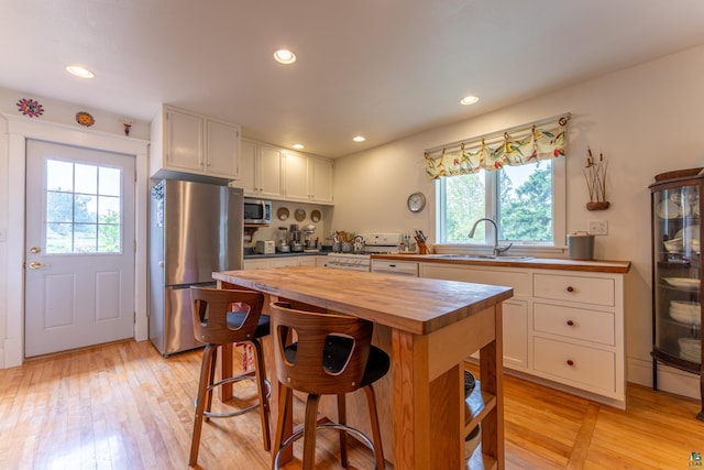 1 W Railroad St, Ely, MN 55731 - kitchen with butcher block countertops, appliances with stainless steel finishes, a sink, white cabinets, and light wood finished floors
