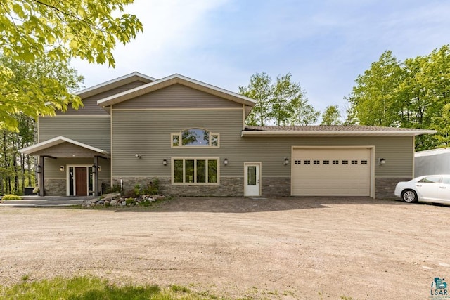 5386 Martin Rd, Duluth, MN 55811 - view of front of home featuring dirt driveway, an attached garage, and stone siding