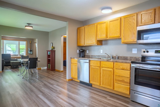 319 N 84th Ave W, Duluth, MN 55807 - kitchen featuring appliances with stainless steel finishes, light wood-style floors, a sink, and baseboards