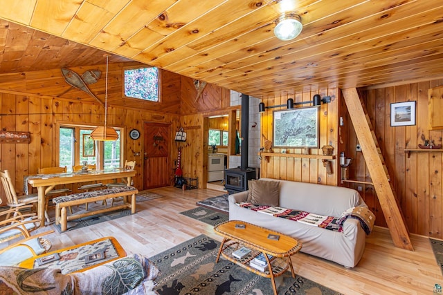 3666 Mackie Rd, Ely, MN 55731 - living room with wood walls, vaulted ceiling, wood ceiling, wood-type flooring, and a wood stove