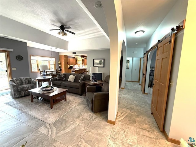 58950 State Highway 23, Sandstone, MN 55072 - living room with a barn door, a ceiling fan, a textured ceiling, and baseboards