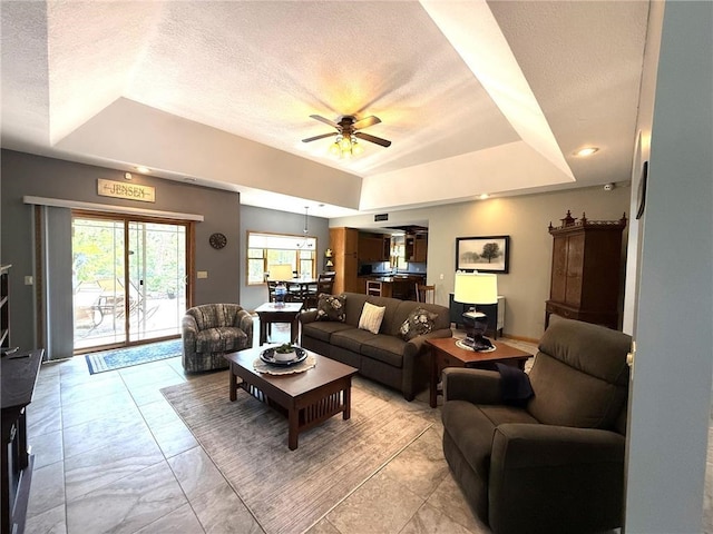 58950 State Highway 23, Sandstone, MN 55072 - living room featuring a raised ceiling, ceiling fan, and a textured ceiling
