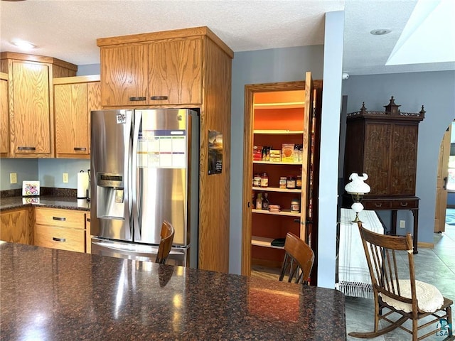 58950 State Highway 23, Sandstone, MN 55072 - kitchen with stainless steel refrigerator with ice dispenser, a textured ceiling, arched walkways, and dark stone counters